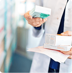 Person reading active ingredients on the package of medicine